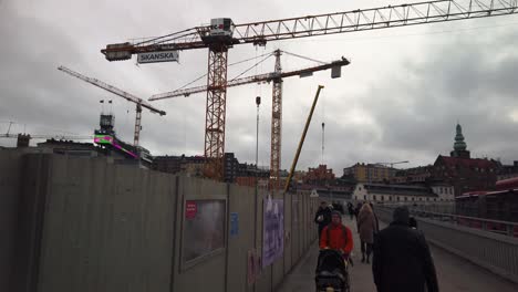 Pedestrians-walk-by-construction-site-at-Slussen-in-Stockholm