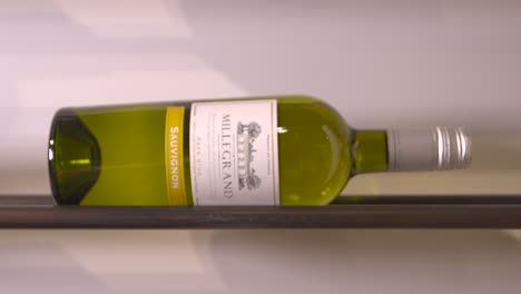 Botella-De-Vino-Blanco-Sauvignon-Tumbada-De-Lado-Sobre-Un-Estante-De-Acero,-Millegrand