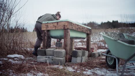 The-Man-is-Removing-Bricks-From-the-Wheelbarrow-and-Placing-them-Near-the-DIY-Hot-Tub---Static-Shot