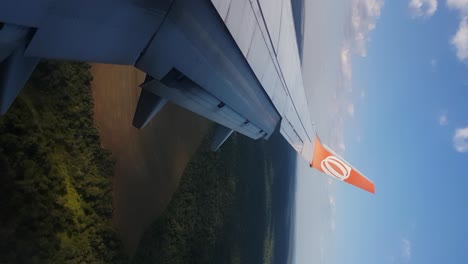 Vertical-View-of-Gol-Airlines-Brazil-Boing-737-Airplane-Wing-Flying-Above-Iguazu-River-and-Rainforest,-Brazil