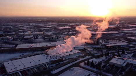 Eine-Luftaufnahme-Der-Dampfenden-Fabrik-Bei-Sonnenuntergang