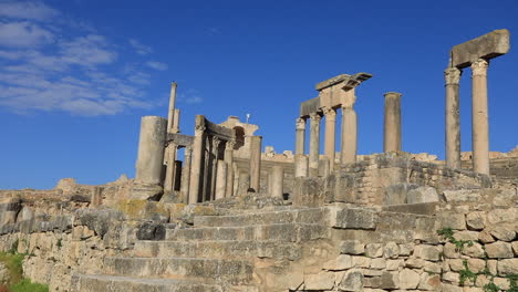 Antiguas-Ruinas-Romanas-En-Dougga-Con-Cielos-Azules,-Mostrando-Historia-Y-Arquitectura