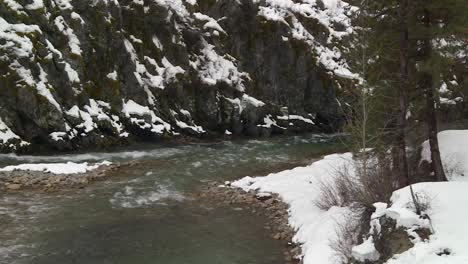 Snowy-Mountain-Stream-Flowing-In-Winter