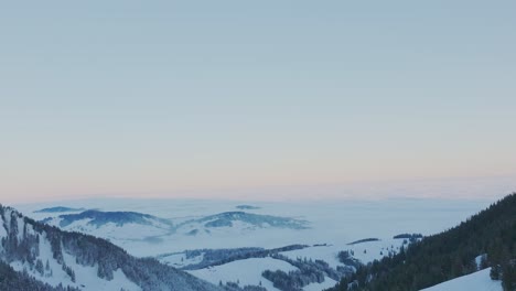 Witness-the-breathtaking-beauty-of-sunrise-over-a-snow-covered-mountain-range-silhouette-through-this-captivating-drone-footage