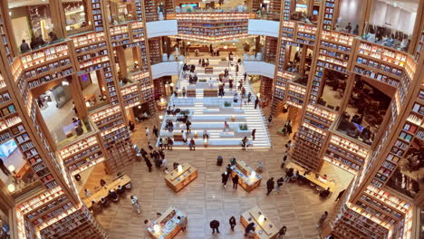 Suwon-Starfield-Library---Menschenmenge-Erkundet-Futuristischen-Buchladen-Mit-Riesigen-Bücherregalwänden-Und-Liest-Sitzend-In-Geräumiger-Halle---Zeitraffer-Von-Oben