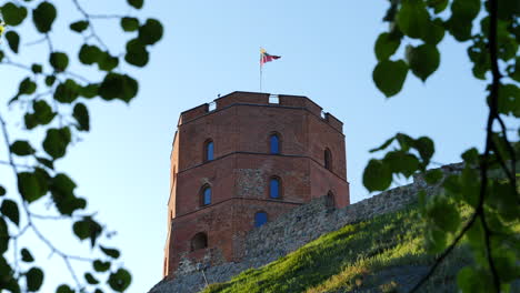 Low-angle-static-shot-of-Gediminas-Tower,-Lithuanian-flag-fluttering,-Vilnius