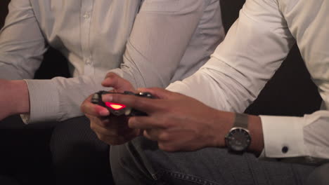 Close-up-of-male-hands-playing-video-game-console-during-break-time,-competitive