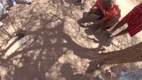 Massai-Mann-Berührt-Trockenen-Afrikanischen-Boden,-Präsentation-Des-Stammeslebens-Und-Der-Bräuche-Für-Touristen