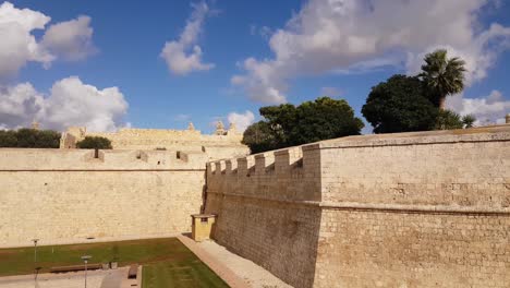 Cielo-Azul-Brillante-Con-Nubes-Blancas-Esponjosas-Sobre-Las-Antiguas-Murallas-Y-Fortificaciones-De-Mdina,-Malta