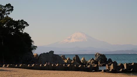 Monte-Fuji-Con-Capa-De-Nieve-En-La-Distancia-Con-Olas-En-La-Playa