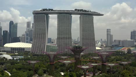 Gardens-by-the-Bay-with-the-Marina-Bay-Sands-Hotel-from-an-Aerial-Panning-Shot-in-Singapore