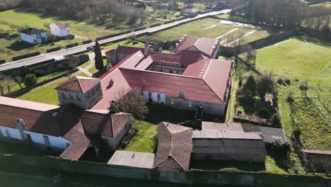 Drone-orbits-around-top-of-monastery-roof-as-sunlight-glistens-from-sun-high-in-the-sky