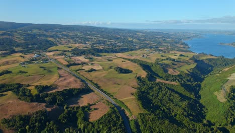 Aerial-shot-of-Chiloé-Island-in-Chile-with-lush-landscapes-and-coastal-view,-sunlight