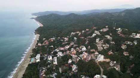 Aerial-Drone-Fly-Above-Sayulita-Beach-coastline-Village-in-Mexican-Green-Jungle-Hills,-White-sand-and-pristine-blue-sea-landscape-in-Latin-American-Pacific-Ocean