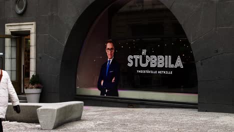 President-of-Finland-Alexander-Stubb-election-office-in-Helsinki-downtown,-man-in-suit-on-billboard-at-Helsinki's-Stubbila-entrance,-daylight
