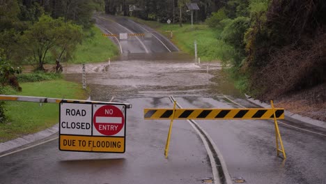 Gold-Coast,-Queensland,-16-February-2024---Signage-indicating-road-closure-due-to-flooding-across-Hardy's-Road-in-Mudgeeraba-after-heavy-rains-continue-to-lash-South-East-Queensland,-Australia