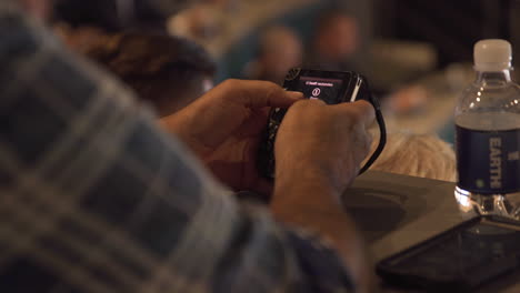 Man-attending-congress-using-small-electrical-device-to-vote,-close-up