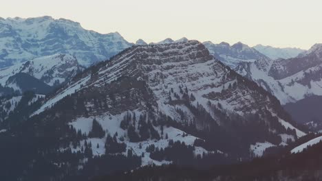 Imágenes-Capturadas-Por-Drones-Que-Ofrecen-Una-Vista-Majestuosa-Del-Amanecer-Sobre-La-Silueta-De-Una-Cadena-Montañosa-Cubierta-De-Nieve.