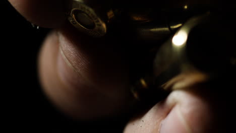 Macro-detail-closeup-of-fingers-holding-and-then-dropping-shiny-bullets