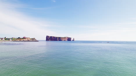 Vista-De-Drones-Avanzando-Hacia-La-Roca-Percé-Sobre-El-Río-San-Lorenzo-Durante-Un-Día-Soleado