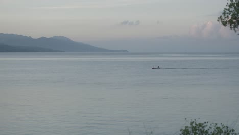 Scenic-seascape-with-islands-in-the-background,-motorboat-navigating-through-the-bay-in-Cebu,-Philippines