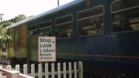 Front-carriage-of-East-Midlands-train-panning-past-leaving-station-and-warning-sign