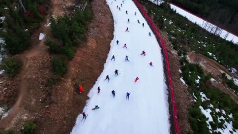 Aerial-view-of-skiers-and-snowboarders-go-downhill,-Dolni-Morava-winter-event