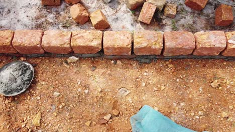 Cemented-and-jointed-earthen-blocks-are-laid,-Stacked-earthen-blocks-in-rows,-Building-the-foundation-of-the-house,-,-Building-a-house-with-red-stone-,-Works-using-cement-