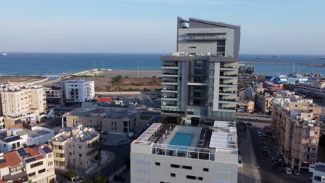 Vuelo-Aéreo-En-Círculos-Sobre-El-Hotel-Radisson-Blu-En-Un-Día-Soleado,-Larnaca,-Chipre
