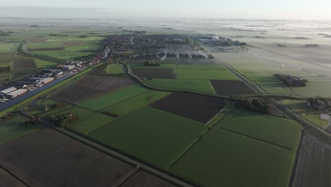 Aerial-view-of-farmland-and-fields-during-a-foggy-morning,-Workum,-Netherlands