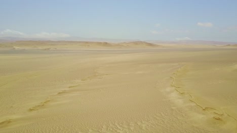 Weite-Wüstenlandschaft-Mit-Luftdrohne,-Die-über-Die-Nach-Unten-Geneigten-Sanddünen-Aufsteigt,-Peru