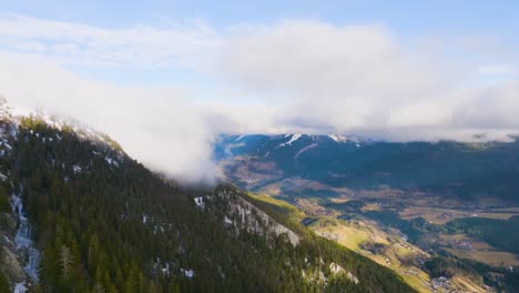 Flying-over-mountain-valley-with-pine-and-strange-falling-clouds,-Chartreuse