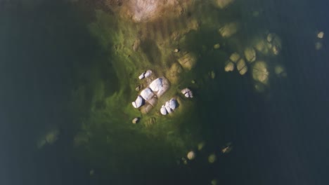 top-down-view-of-a-rocky-outcrop-underwater-in-shaver-lake-california-with-ripples-and-light-reflections-on-top-of-the-water-mid-day-60fps