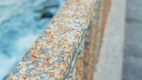 Eroded-handrail-on-Atlantic-ocean-coastline,-close-up-view