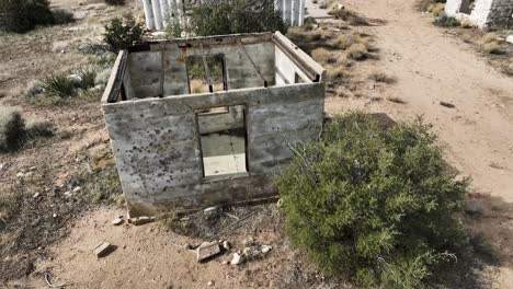 abandoned-building-concrete-structures-destroyed-by-the-cartel-with-bullet-holes-in-the-side-in-the-high-desert-of-southern-California-on-an-overcast-day-with-an-apocalyptical-mood-60fps