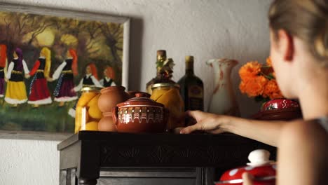 Countryside-kitchen-scene,-Woman-picking-and-placing-Bulgarian-traditional-Kitchenware