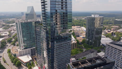 Waving-american-flag-on-top-of-tower-in-financial-district-with-mirrored-Skyscraper-buildings