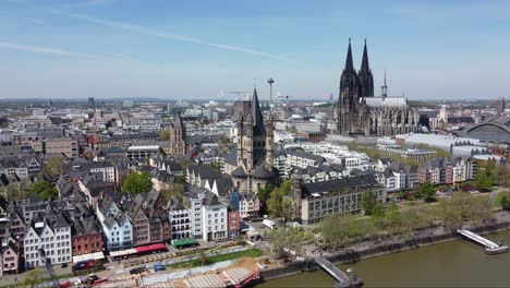 Cologne-city-landmarks-and-colorful-waterfront-houses-on-sunny-day,-Aerial