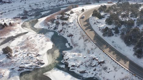 Temprano-En-La-Mañana,-Escena-Del-Río-De-Invierno-Nevado-Desde-Arriba-A-Lo-Largo-De-Una-Carretera-O-Autopista