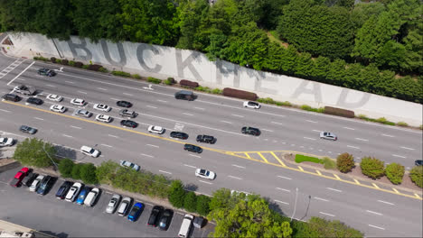 Aerial-flyover-with-vehicles-beside-highway-in-Buckhead-District-of-Atlanta-City,-USA