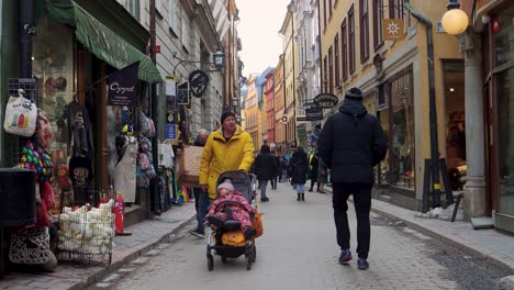 Winter-shopping-scene-on-Västerlånggatan-in-Stockholm's-Old-Town,-street-level-view-with-pedestrians