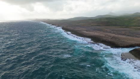 Barren-northside-of-Caribbean-island-bombarded-with-strong-ocean-waves-at-drop-off-passing-river-mouth