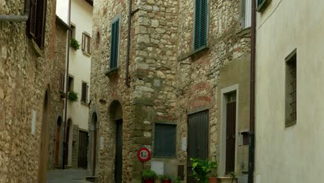 Establishing-shot-tilt-up-of-the-stone-facade-of-a-quiet-residential-area-of-Radda,-a-village-in-the-Chianti-Region-of-Tuscany,-Italy