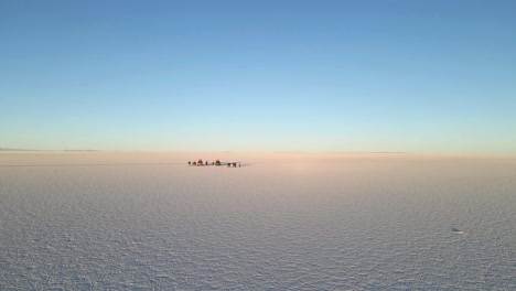 The-drone-captures-the-enchanting-beauty-of-the-Uyuni-desert-as-it-moves-forward-in-fast-pace-and-reveals-some-tourists-in-the-desert