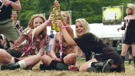 Adult-woman-enjoying-bottles-of-wine-together-relaxing-on-the-ground-at-festival