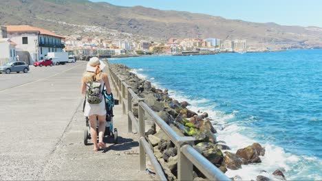 Madre-Joven-Con-Cochecito-De-Bebé-Caminando-Por-La-Costa-Del-Municipio-De-Candelaria