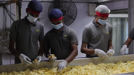 pov-shot-Men-are-removing-bad-chips-and-preparing-the-chips-for-packaging