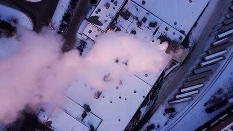A-top-down-aerial-shot-of-the-steaming-factory-in-winter