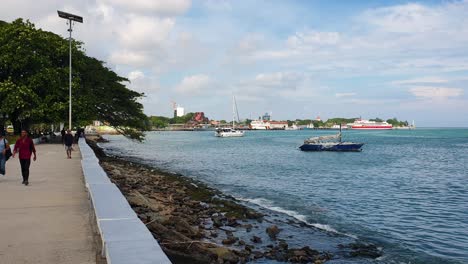 Scenic-harbour-ocean-view-with-docked-tourism-boats-from-popular-walking-spot-on-the-waterfront-in-the-capital-city-of-East-Timor,-Southeast-Asia