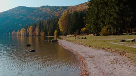 Autumnal-scenery-at-Lake-Sfanta-Ana,-Harghita-with-calm-waters-and-colorful-trees